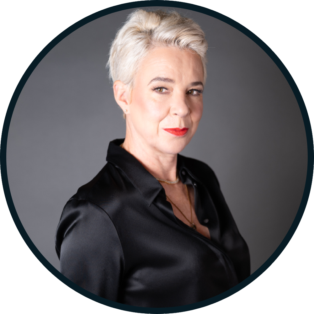Confident mature woman with short gray hair in black satin blouse.
