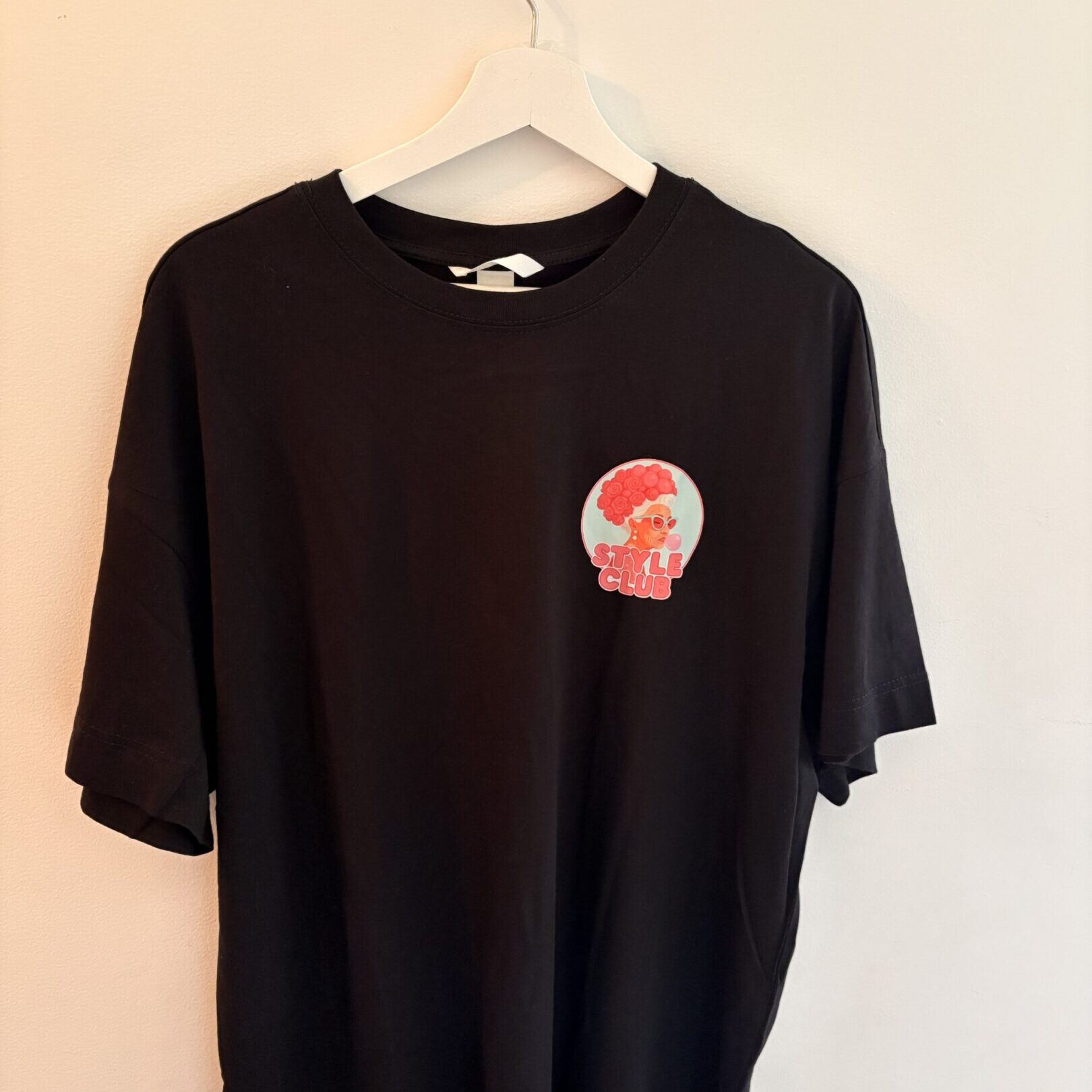 Black t-shirt with a small red and white graphic on the chest.